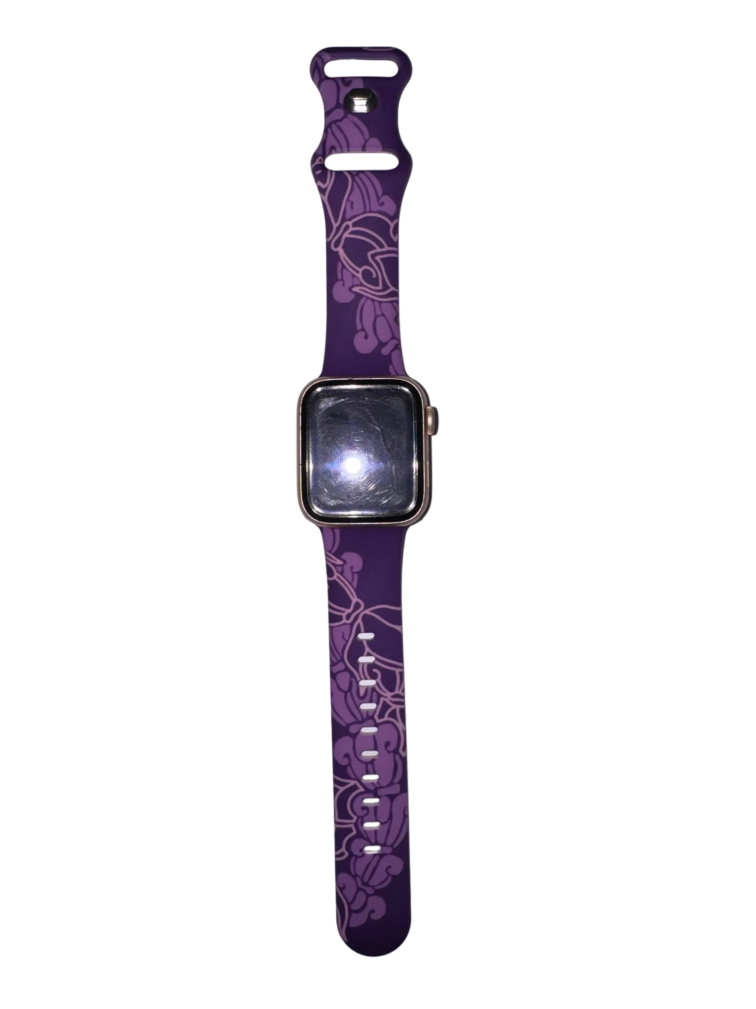 A purple smartwatch band with a floral pattern, attached to a smartwatch, displayed vertically against a plain light gray background.